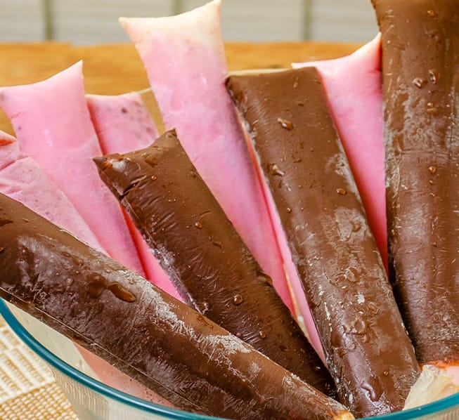 Geladinhos de morango e chocolate num recipiente de vidro
